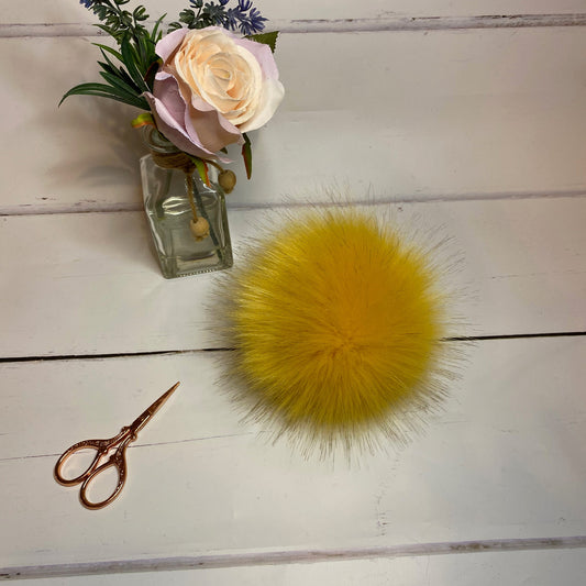 Ochre coloured faux fur pom pom