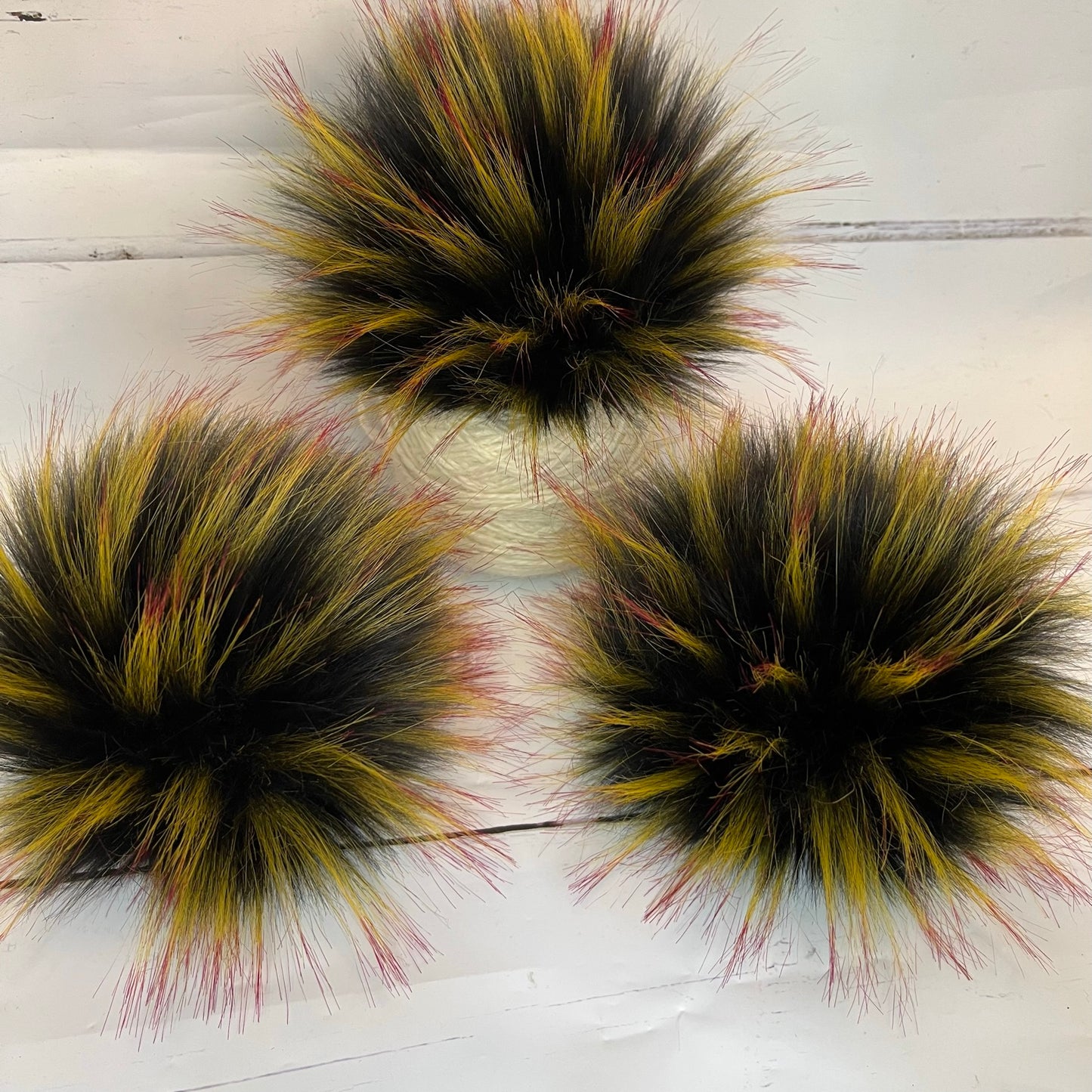 Mockingjay coloured faux fur pom pom - a black with yellow and red tips. Detachable option
