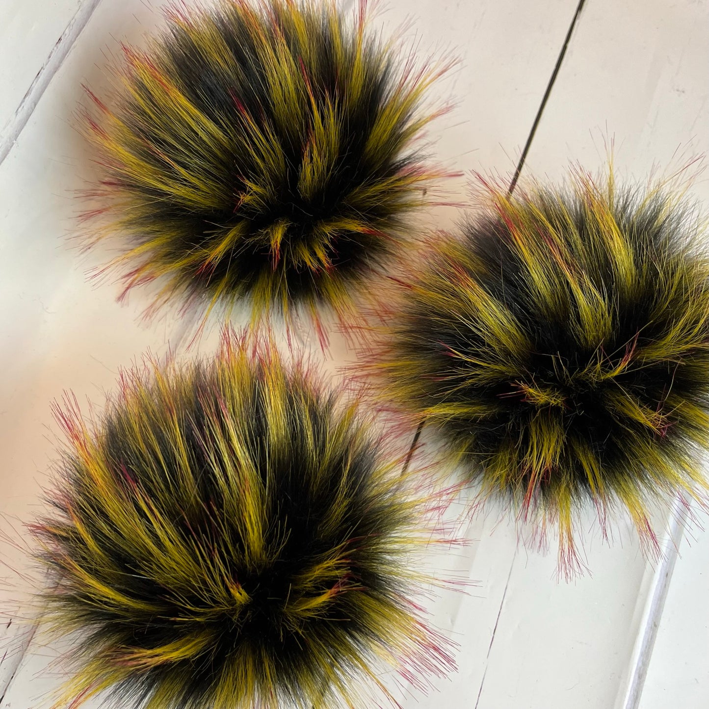 Mockingjay coloured faux fur pom pom - a black with yellow and red tips. Detachable option